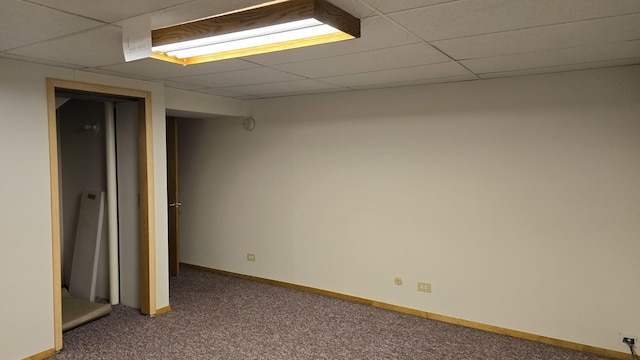 finished basement featuring carpet, a drop ceiling, and baseboards