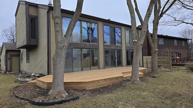 rear view of house with a deck and a yard