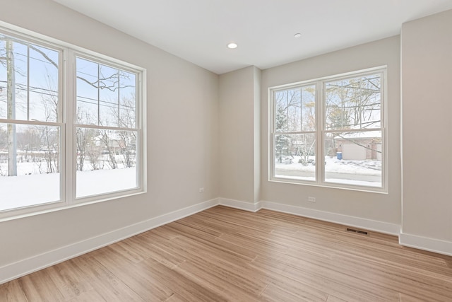 unfurnished room with light wood-style floors, recessed lighting, and baseboards