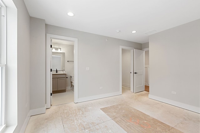 unfurnished bedroom with baseboards, ensuite bathroom, and recessed lighting