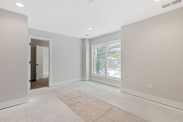 empty room featuring recessed lighting, visible vents, and baseboards