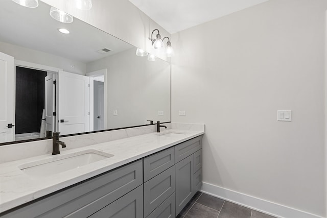 full bath with double vanity, baseboards, a sink, and tile patterned floors