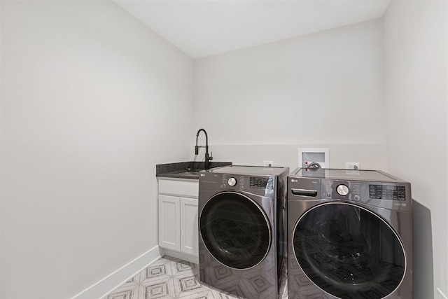 laundry room with cabinet space, baseboards, separate washer and dryer, and a sink