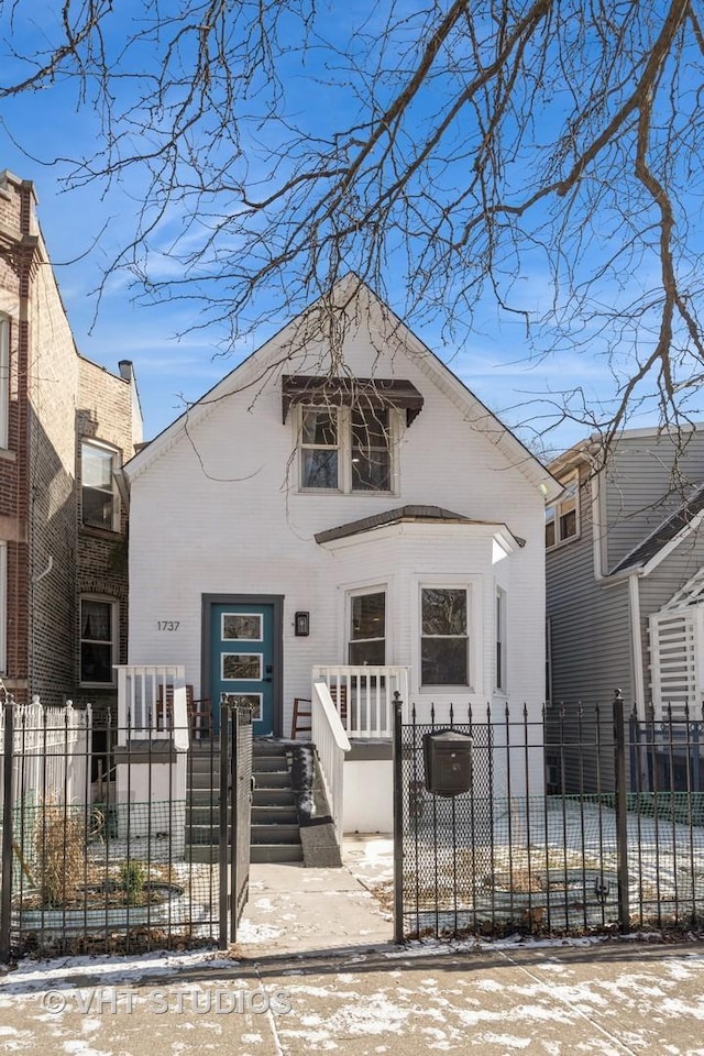 view of front of home with a fenced front yard and a gate