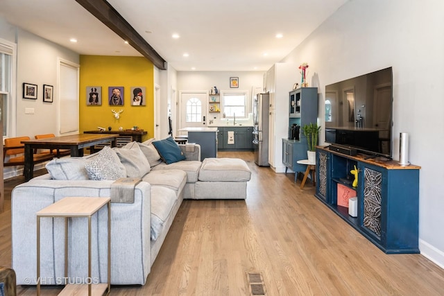 living room with visible vents, baseboards, light wood-style flooring, and recessed lighting