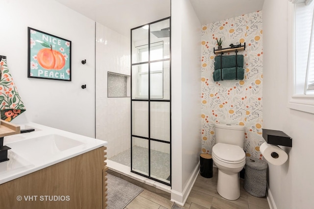 bathroom featuring toilet, double vanity, baseboards, and a walk in shower