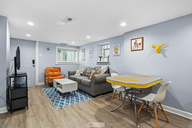 living area featuring visible vents, baseboards, wood finished floors, and recessed lighting