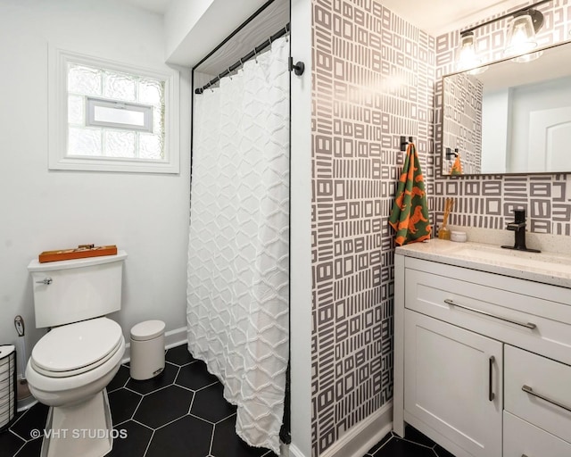 bathroom featuring a shower with shower curtain, toilet, vanity, baseboards, and tile patterned floors