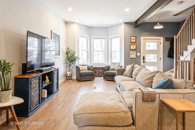 living area featuring beamed ceiling, stairway, light wood-style flooring, and recessed lighting