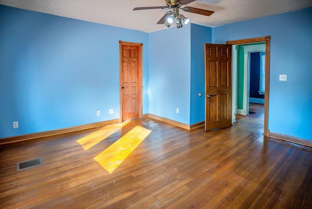 unfurnished room with a ceiling fan, baseboards, visible vents, and wood finished floors