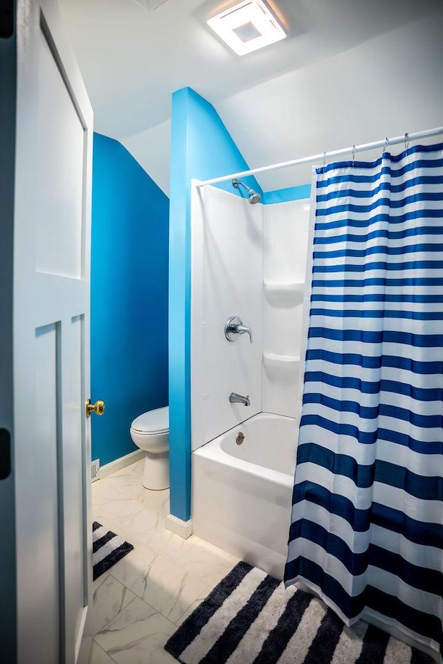 bathroom featuring marble finish floor, shower / bath combination with curtain, toilet, and baseboards