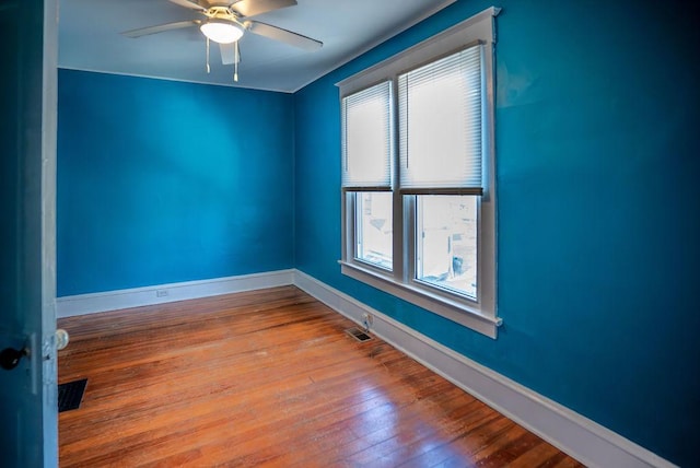 empty room with a ceiling fan, light wood-type flooring, visible vents, and baseboards