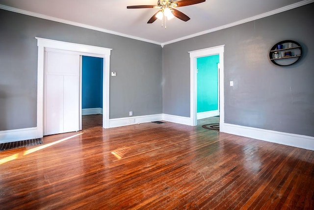 spare room with ornamental molding, wood finished floors, a ceiling fan, and baseboards