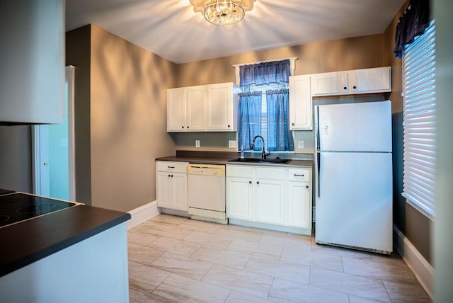 kitchen featuring white appliances, a sink, white cabinetry, baseboards, and dark countertops