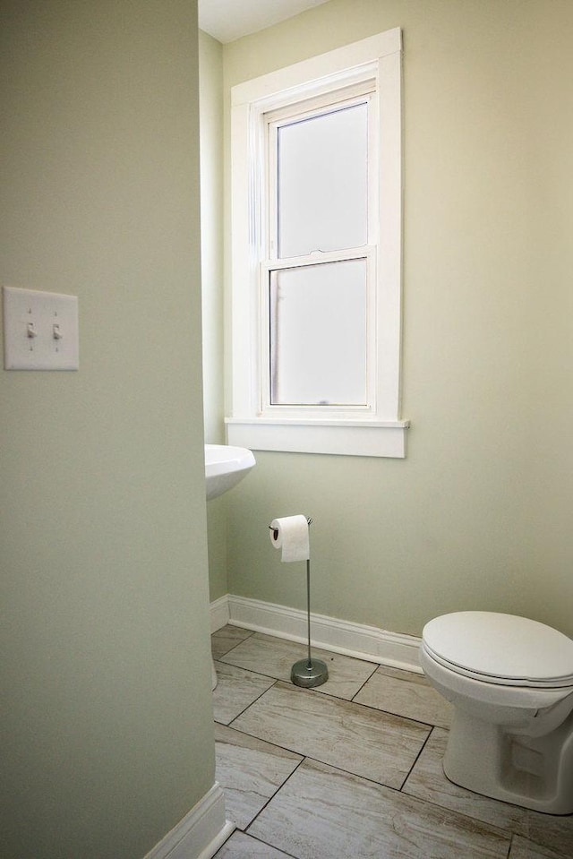 half bath with toilet and baseboards