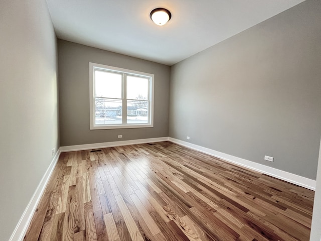 spare room with light wood-style flooring and baseboards