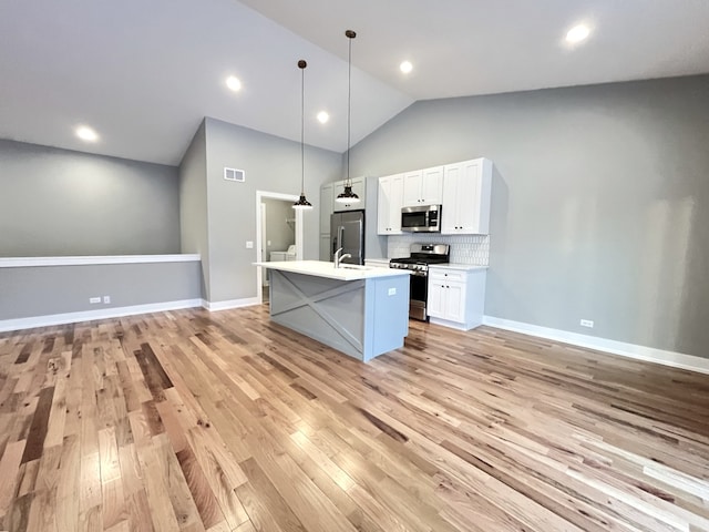 kitchen with stainless steel appliances, visible vents, white cabinetry, light countertops, and pendant lighting