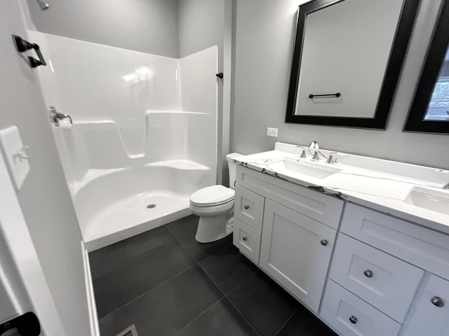 bathroom with a shower, double vanity, toilet, a sink, and tile patterned flooring