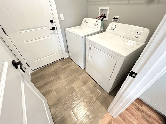 laundry area featuring laundry area, light wood-type flooring, and independent washer and dryer