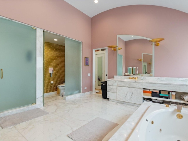 full bathroom featuring baseboards, toilet, a tub with jets, marble finish floor, and vanity