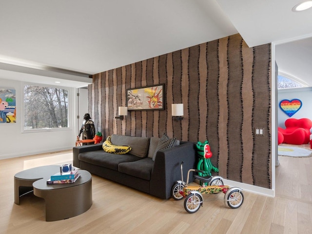 living area with wood finished floors and wallpapered walls