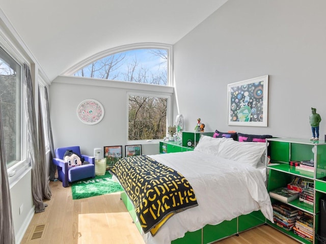 bedroom featuring lofted ceiling, wood finished floors, and visible vents