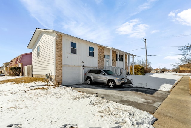 bi-level home featuring aphalt driveway and an attached garage