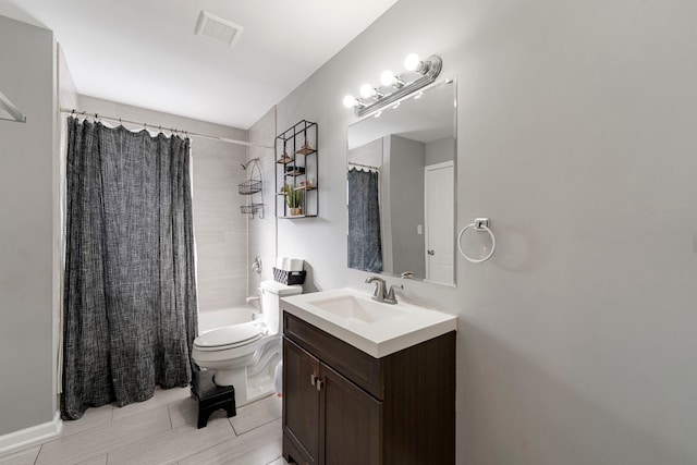 bathroom with visible vents, toilet, vanity, and shower / tub combo with curtain