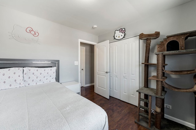 bedroom featuring dark wood-style floors, baseboards, and a closet