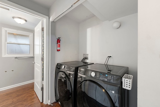 laundry room featuring wood finished floors, visible vents, baseboards, laundry area, and washing machine and dryer