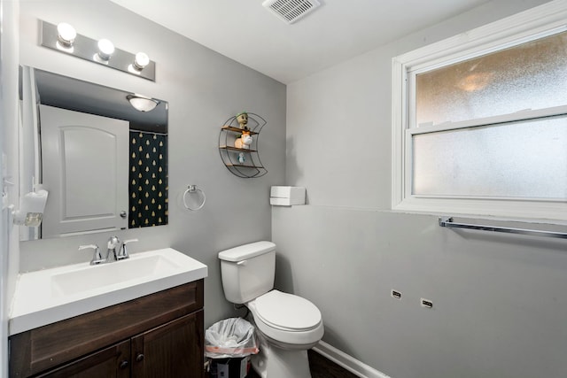 bathroom with visible vents, baseboards, toilet, and vanity