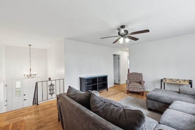 living room featuring light wood-type flooring and ceiling fan with notable chandelier