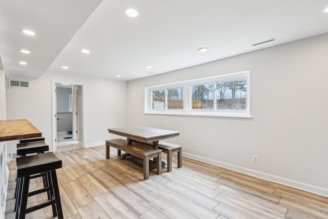dining area featuring light wood-style floors, baseboards, and visible vents