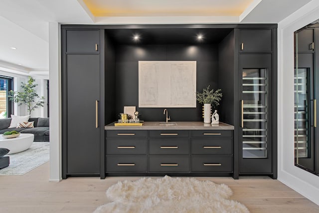 bar featuring wine cooler, recessed lighting, a sink, light wood-type flooring, and wet bar