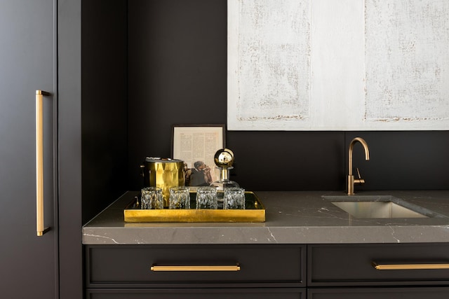 kitchen with dark countertops, a sink, and refrigerator