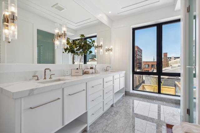 full bath with a sink, visible vents, marble finish floor, a view of city, and double vanity