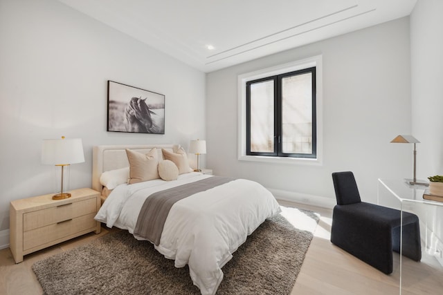 bedroom with light wood-style flooring and baseboards