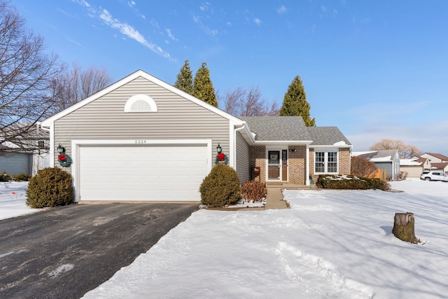 ranch-style house featuring a garage, driveway, and brick siding