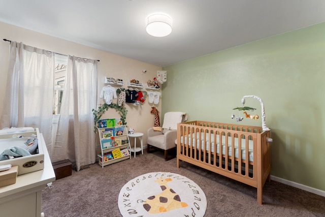 carpeted bedroom with a crib and baseboards