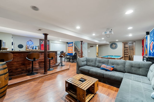 living area featuring wood finished floors, pool table, stairs, a bar, and recessed lighting