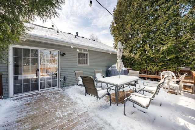 snow covered deck featuring outdoor dining space