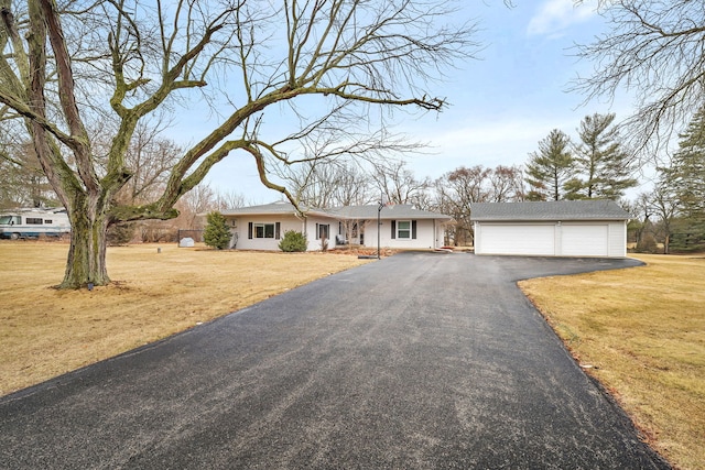 ranch-style house with an outdoor structure, a detached garage, and a front lawn