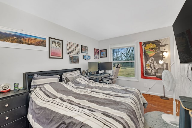 bedroom featuring baseboards and wood finished floors