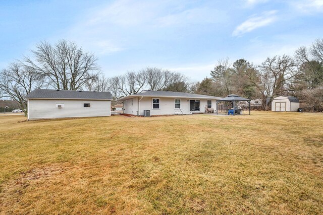 back of property with a storage shed, an outbuilding, a lawn, and a gazebo