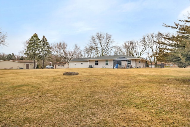 back of house with an outdoor fire pit, a lawn, and a gazebo