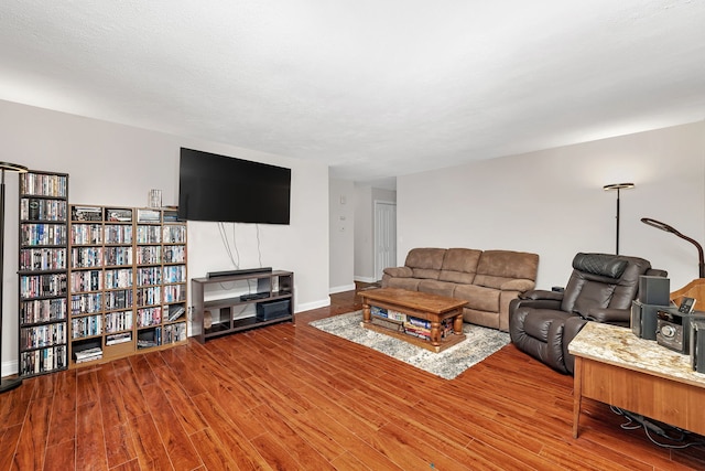 living area with baseboards and wood finished floors