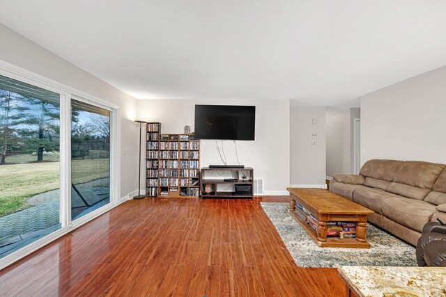 living room featuring visible vents, baseboards, and wood finished floors