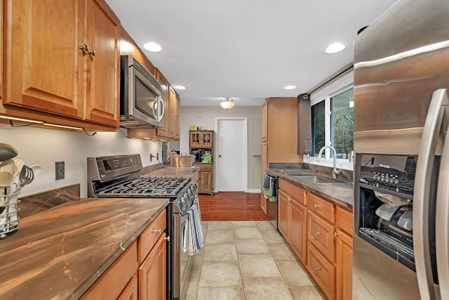 kitchen featuring stainless steel appliances, recessed lighting, brown cabinets, and a sink