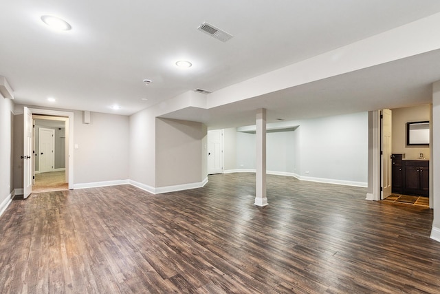 finished basement with dark wood-style flooring, recessed lighting, visible vents, and baseboards