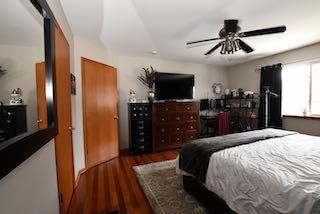 bedroom with ceiling fan and wood finished floors